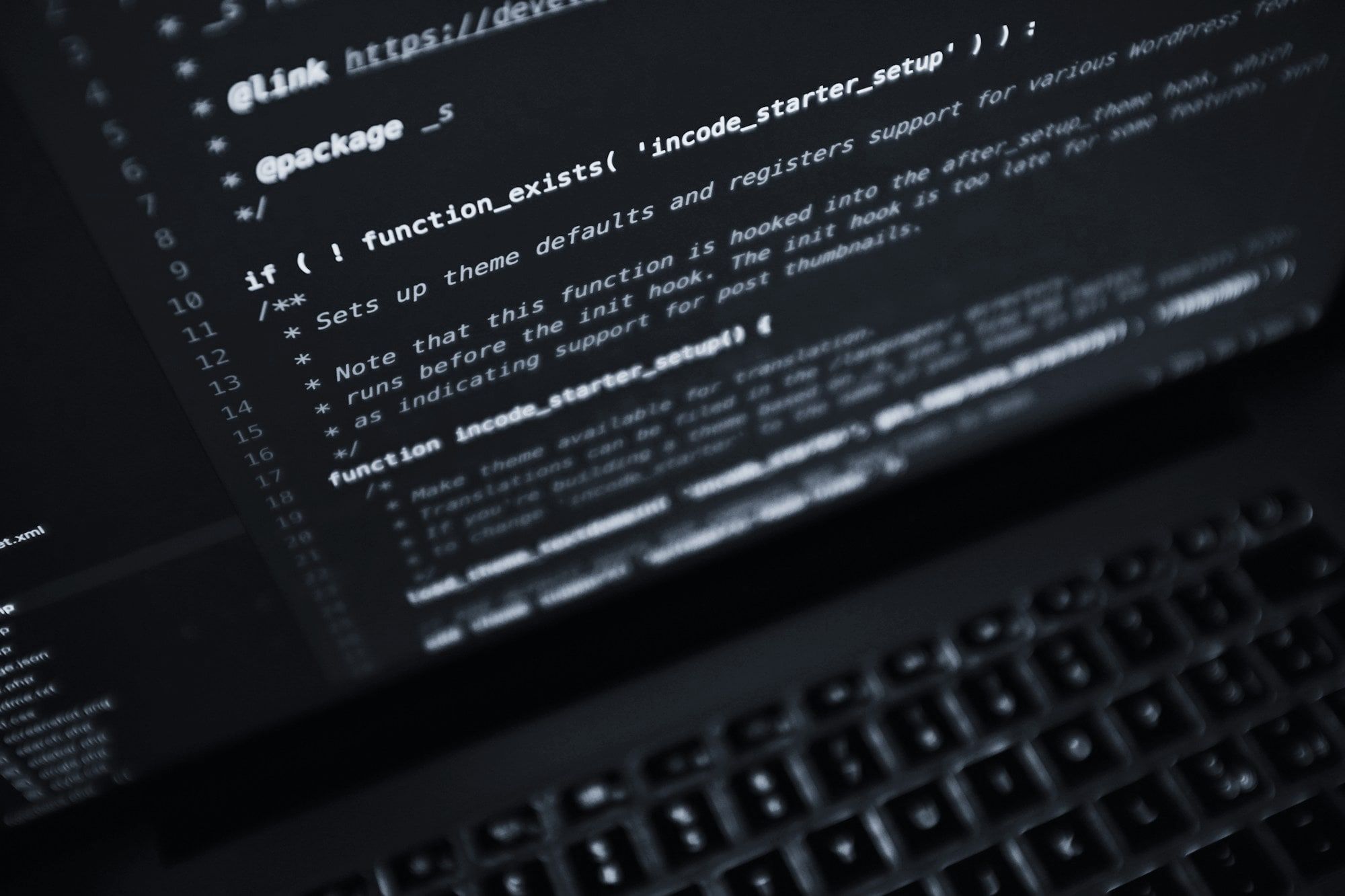 Code on a laptop screen in a dark room