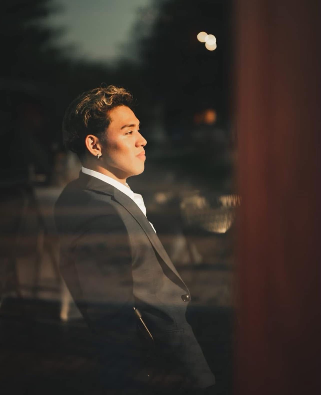 Kevin Pecho of Nyxlane Studio, in a dark suit, in warm evening light